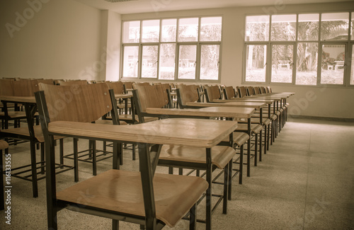 Chair in empty classroom, lecture armchairs in school, or colleg