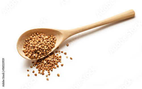 Fotografija Wooden spoon with dry buckwheat