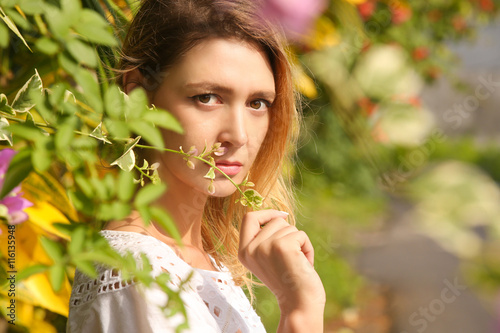 Flower power.  Head shoot of young woman surrounded by flowers.