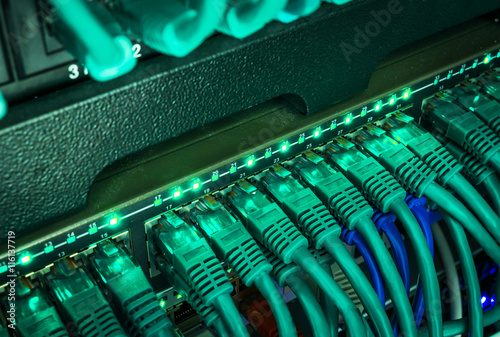 Close up of blue network cables connected to switch glowing in the dark