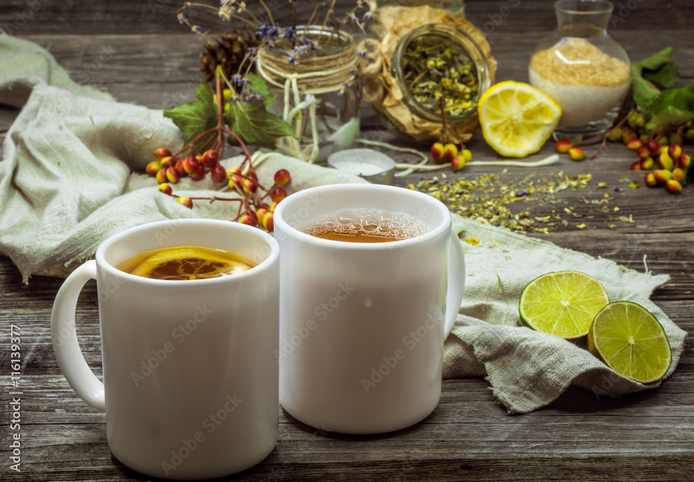 two cups of tea on a beautiful wooden background with lemon and herbs, winter ,autumn two cups of tea on a beautiful wooden background with lemon and herbs, winter ,autumn