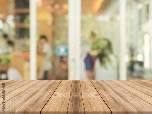 Wooden board empty table in front of blurred background. Perspective brown wood over blur in coffee shop - can be used for display or montage your products.Mock up for display of product. © tirachard