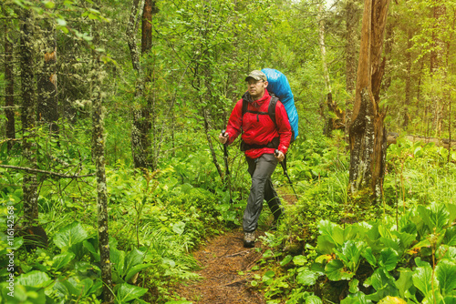 man with backpack hiking in forest