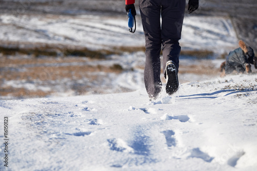 The legs of a hiker walking through a snow covered winter landsc