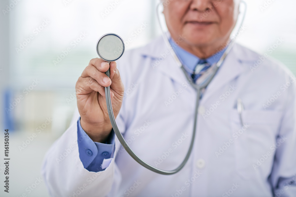 Cropped image of doctor holding stethoscope in front of him Cropped image of doctor holding stethoscope in front of him