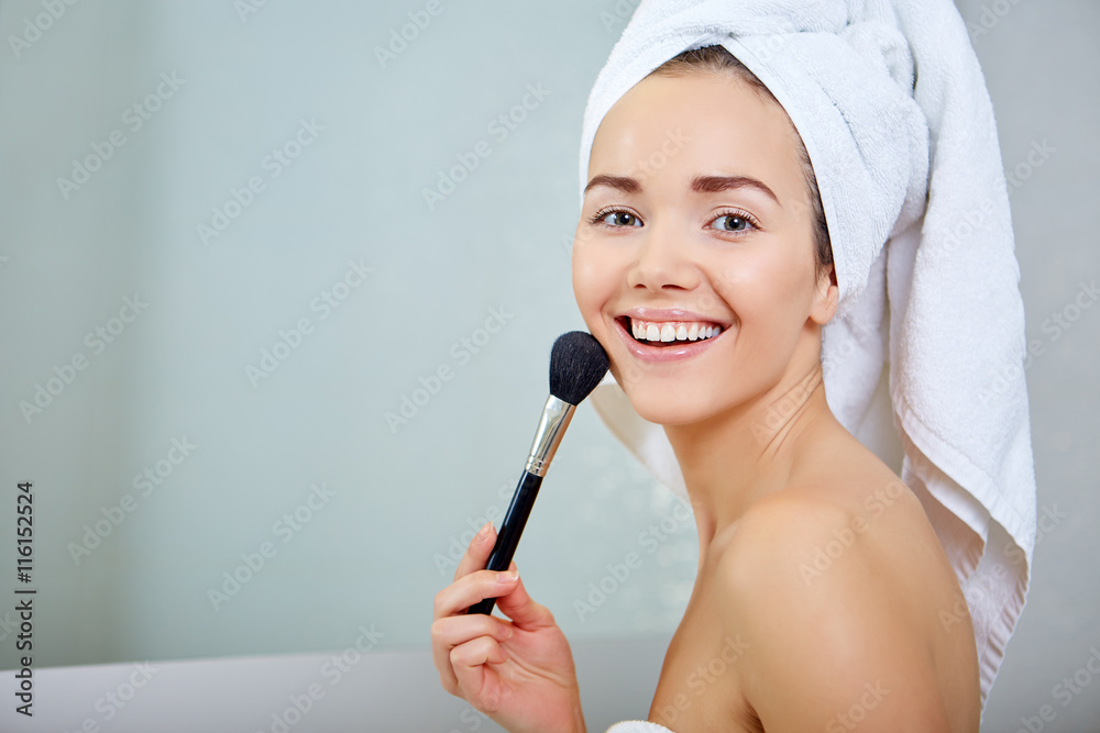 Beauty woman applying makeup. Beautiful girl looking in the mirr