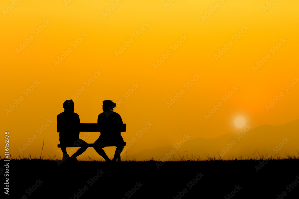 A silhouette of sweetheart on the bench in sunset