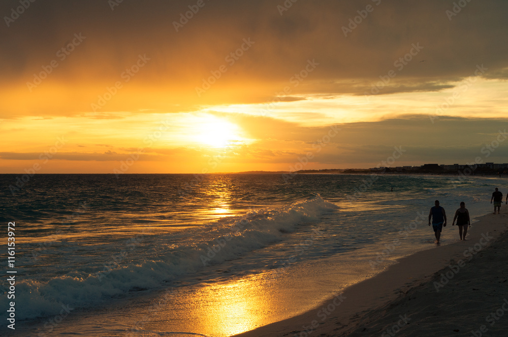 Sonnenuntergang am Meer. Paar geht am Strand spazieren.