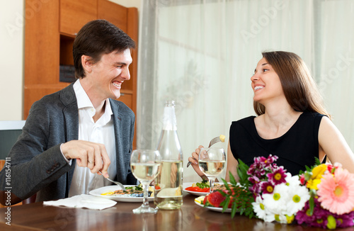 Young man and cute woman having romantic dinner in home