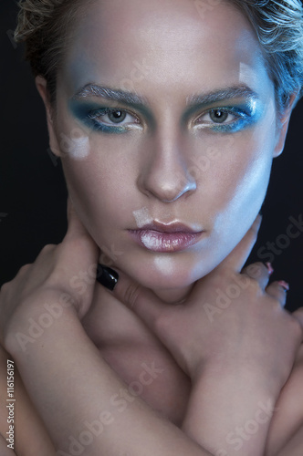 Winter woman portrait. Beautiful fashionable model with white short hair and blue eyes closeup. Creative make up.