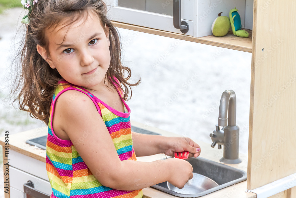 outdoor portrait of young happy smiling girl playing toy kitchen outdoor portrait of young happy smiling girl playing toy kitchen