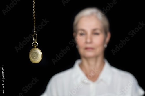 Woman being hypnotized with pendulum  photo