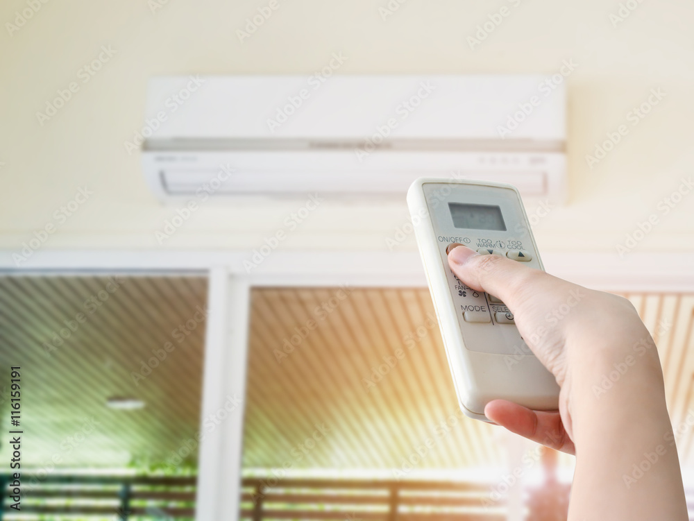 Hand hold remote control directed on the air conditioner Hand hold remote control directed on the air conditioner