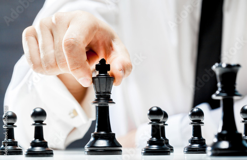 Hand of businessman playing chess