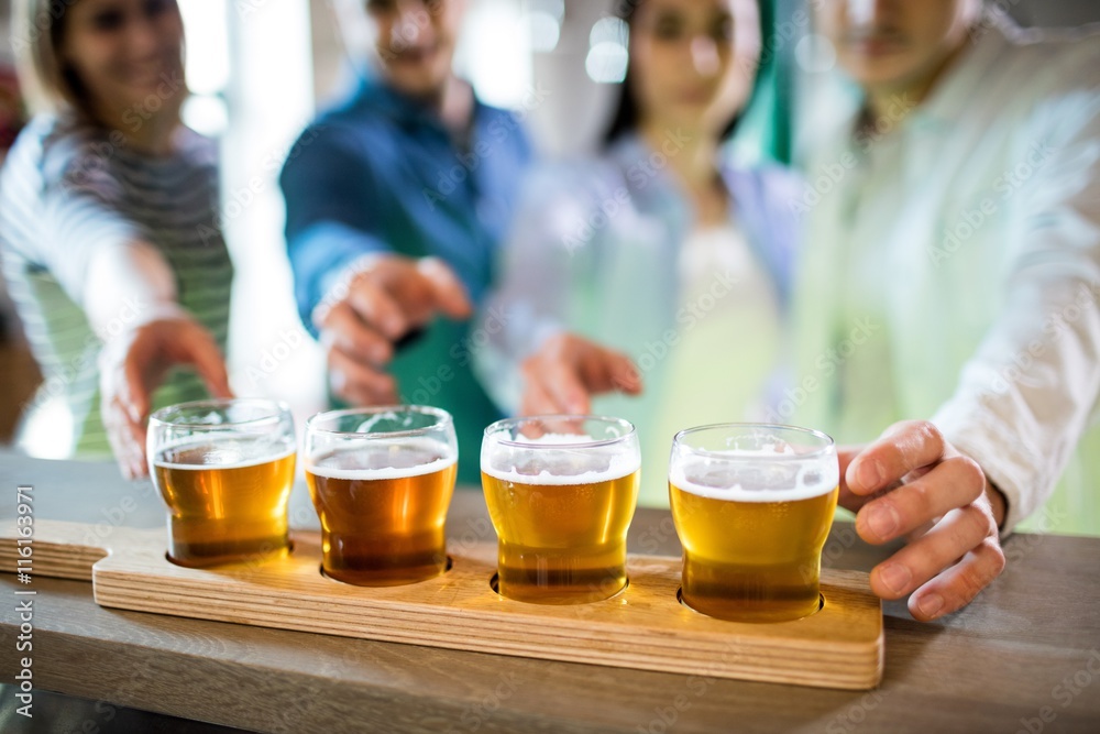Foto Friends reaching towards beer sampler