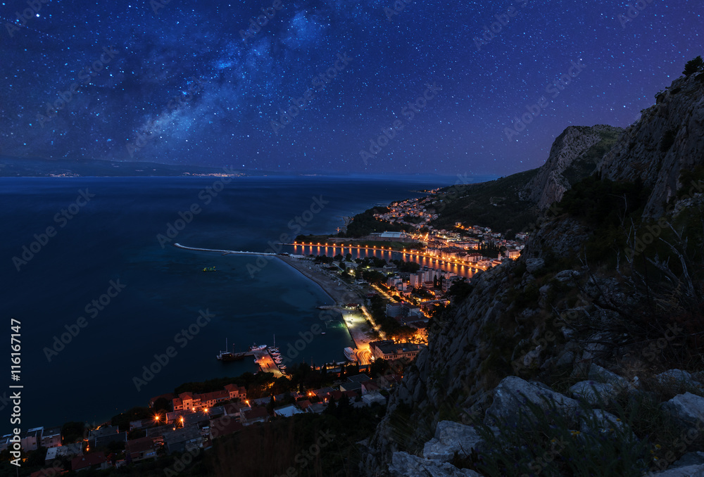 Fototapeta premium Aerial night view - Milky way over the town Omis and Adriatic coast of Mediterranean Sea, Dalmatia, Croatia