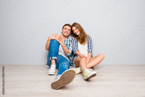 Young happy couple in love sitting on the floor photo