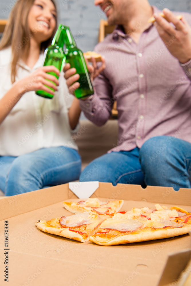 Happy couple in love spending holiday with pizza and beer Happy couple in love spending holiday with pizza and beer