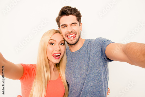 Comic selfie of man and woman in love showing tongues