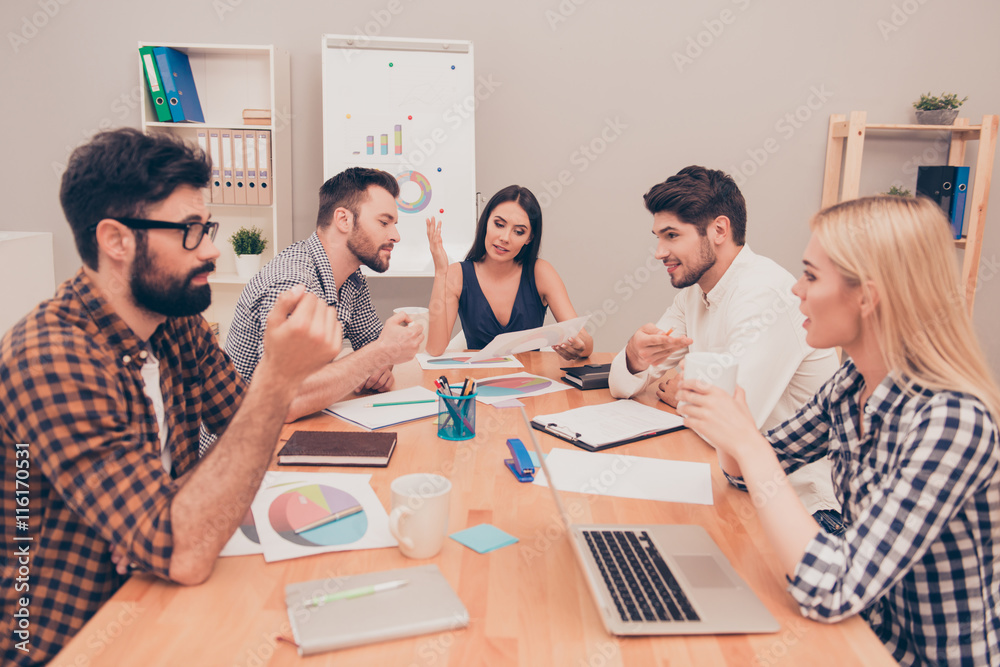 Fototapeta premium young managers conversing at conference table, they planning new