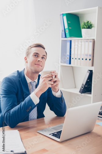 Young businessman drinking tea and dreaming about new project