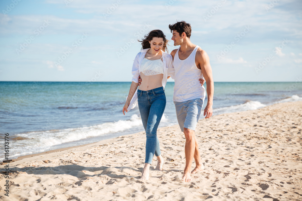 Couple talking and walking on the beach together Couple talking and walking on the beach together