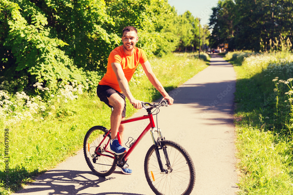 happy young man riding bicycle outdoors