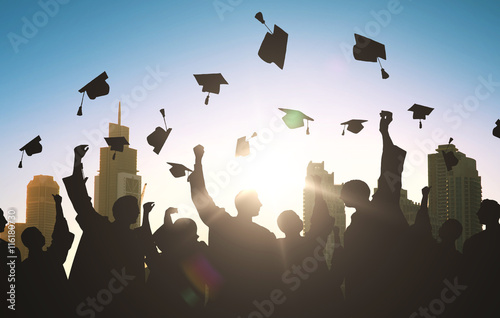 silhouettes of students throwing mortarboards