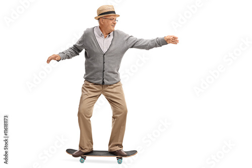 Joyful senior man riding a skateboard