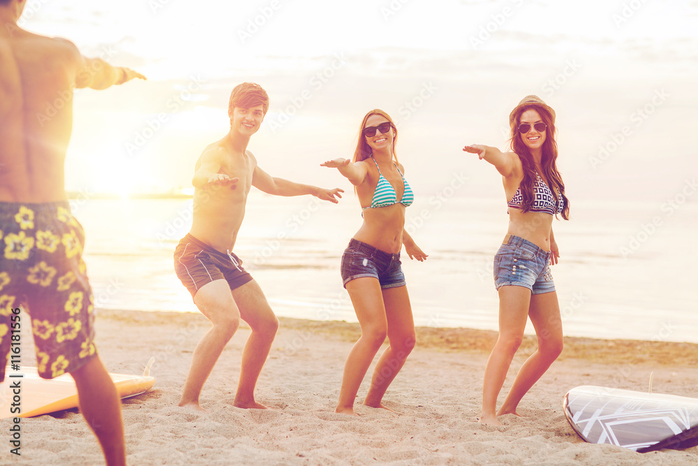 smiling friends in sunglasses with surfs on beach smiling friends in sunglasses with surfs on beach