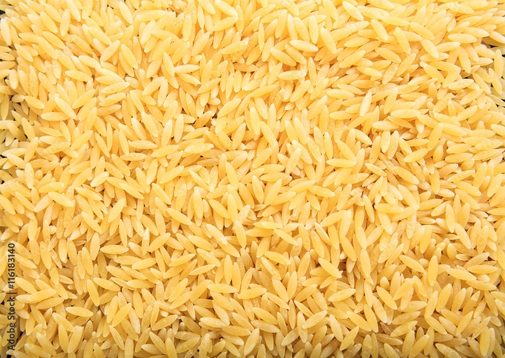 Full background of raw orzo pasta