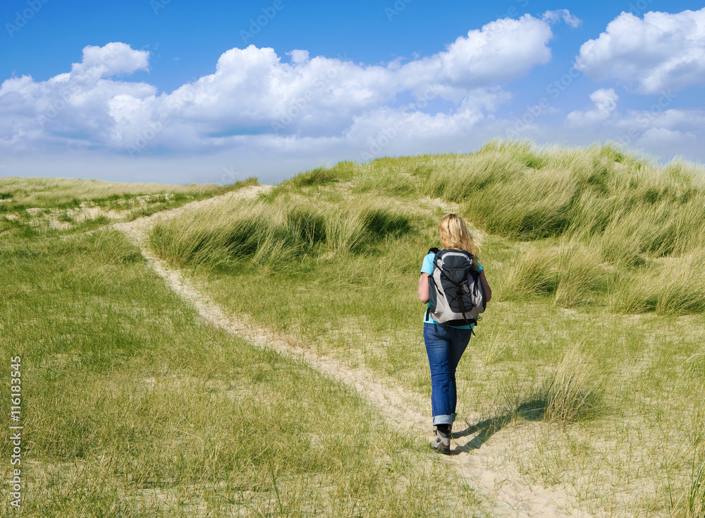 Frau beim Wandern in Dünen