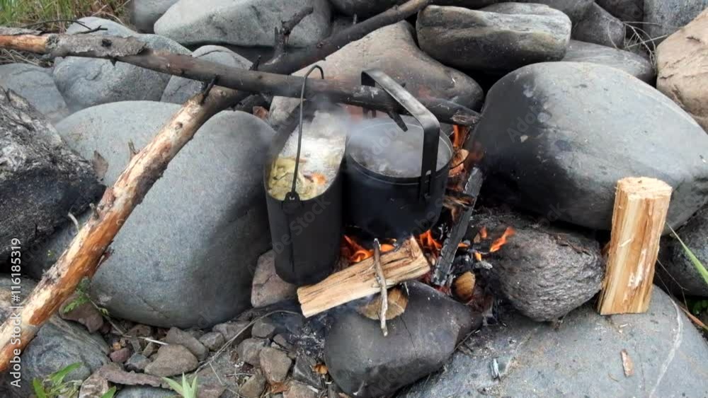 Pots of food boiling on a camp fire Pots of food boiling on a camp fire