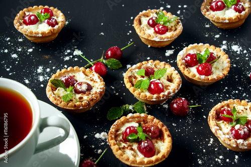 Tartlets with whipped cream and cherry.