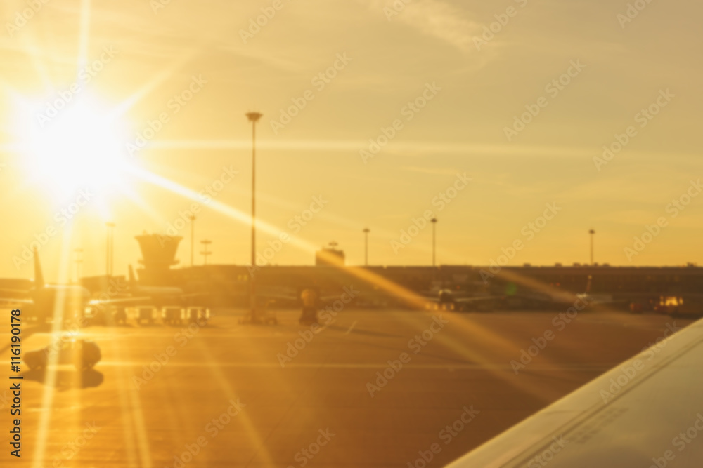 Blurred panorama of an airport with plane and part a terminal at sunrise light. Blurred panorama of an airport with plane and part a terminal at sunrise light.