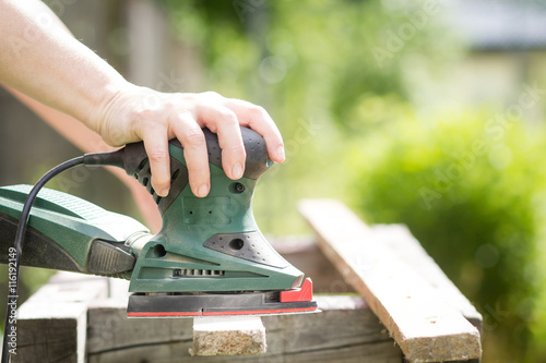 Fotografie Senior woman / girl / lady sanding a pieces of wood by electric