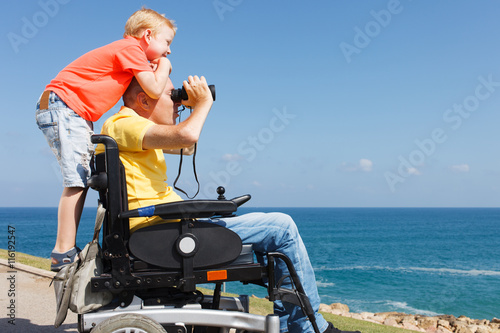 Disabled father and son play with Binocular