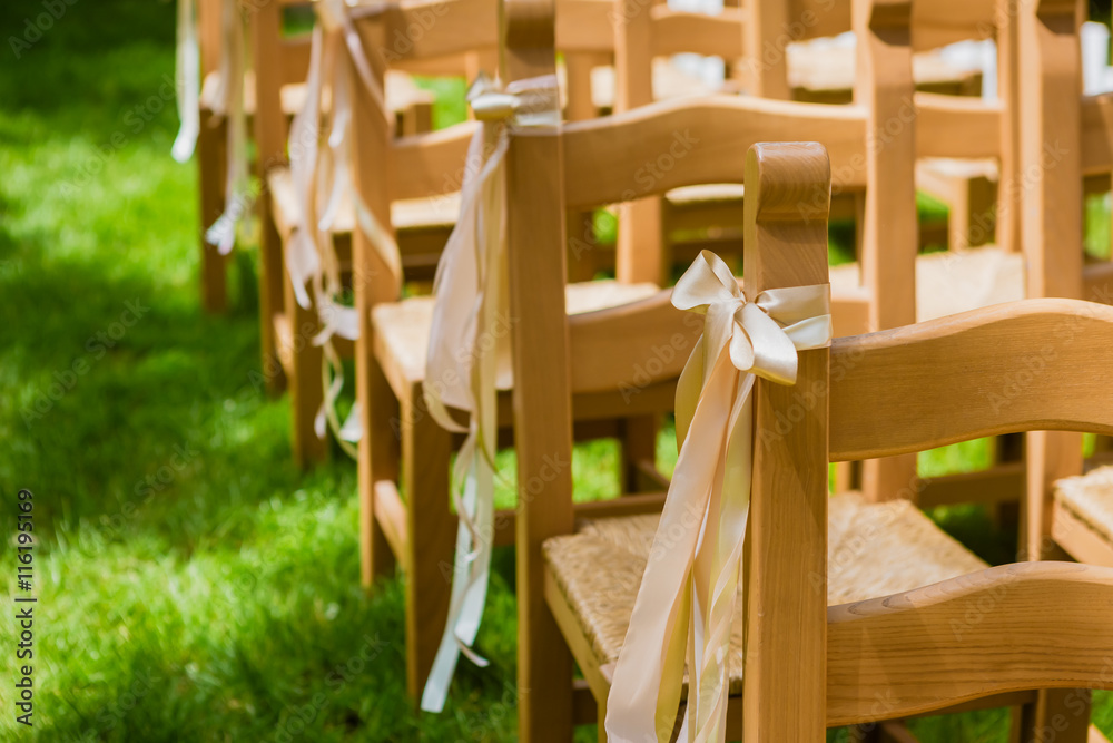 wooden decorated empty chairs on a lawn before wedding ceremony wooden decorated empty chairs on a lawn before wedding ceremony