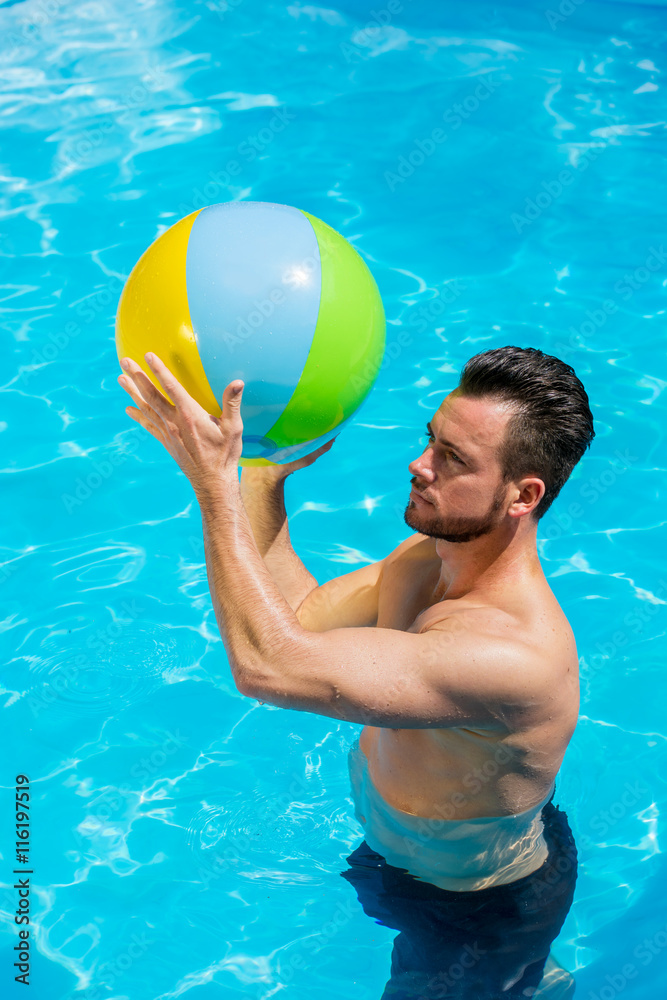Mann spiel im Pool mit einem Wasserball