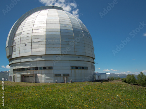 Observatory stands on a hill on the sky background