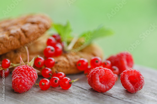 Outmeal biscuits with berries and mint on wooden background photo