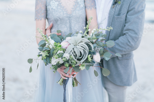 Newly married couple holding wedding bouquet