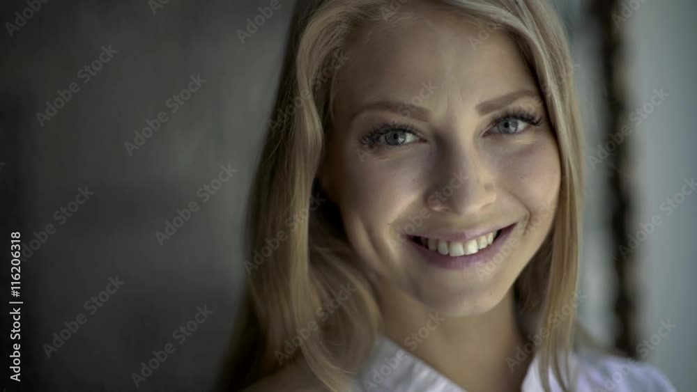 Close up Of A Smiling blond woman with natural makeup wearing white shirt Close up Of A Smiling blond woman with natural makeup wearing white shirt