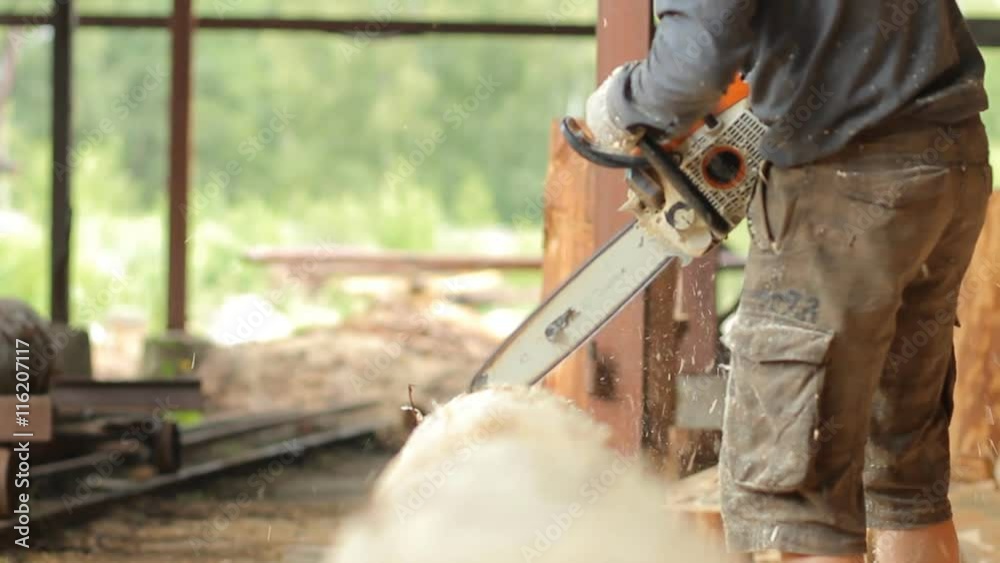 Man cuts off beam chainsaw for future home. Man cuts off beam chainsaw for future home. He dropped a lot of sawdust Man cuts off beam chainsaw for future home. Man cuts off beam chainsaw for future home. He dropped a lot of sawdust