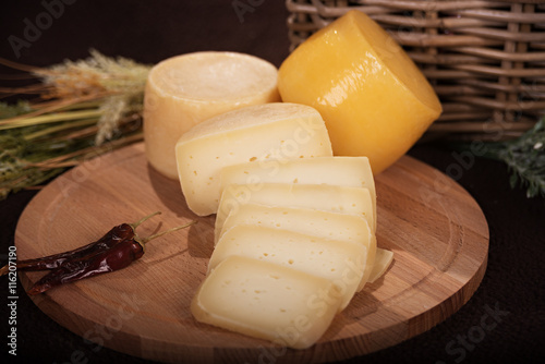 Various cheeses on the wooden board photo