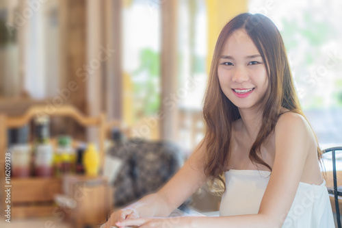 Asia woman sitting in restaurant with smile as restaurant backgr