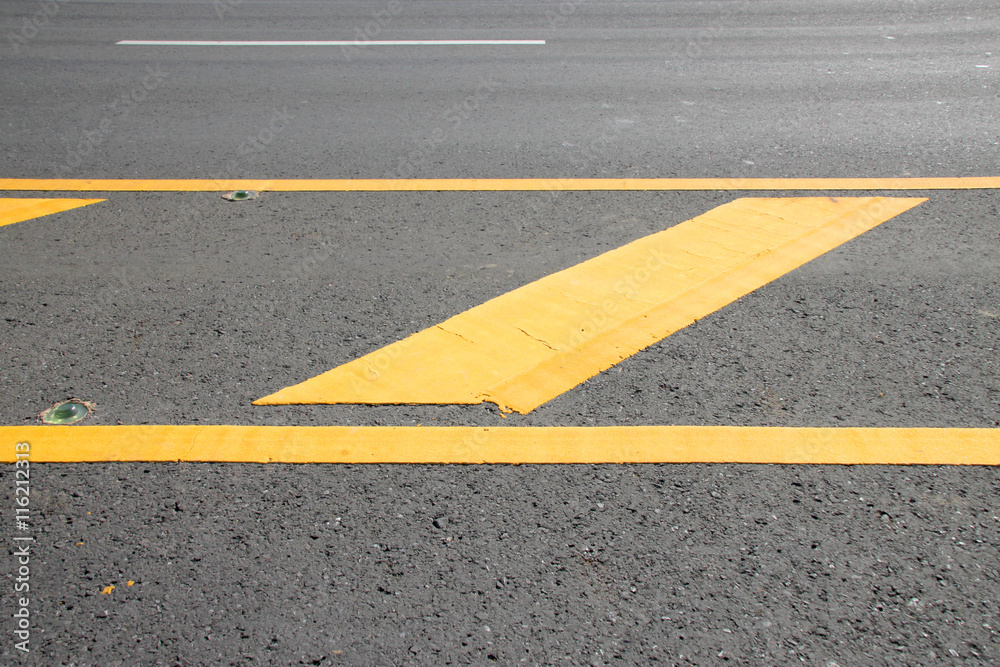 yellow warning sign on asphalt road