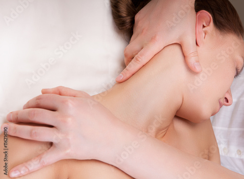 Therapist doing massage on a woman's neck by extending neck muscles