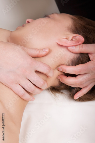 A woman getting a stress relieving pressure point massage on her neck