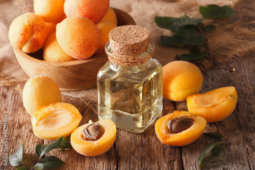 apricot kernel oil in a glass jar closeup and ingredients. Horizontal 